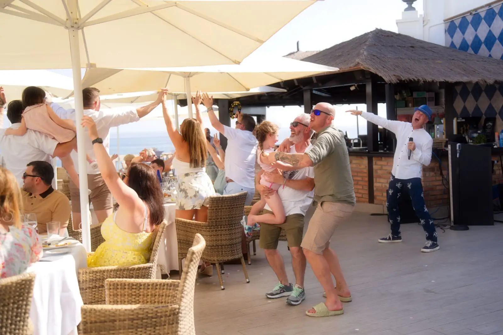Ian Preston singing at a beachfront restaurant as guests dance