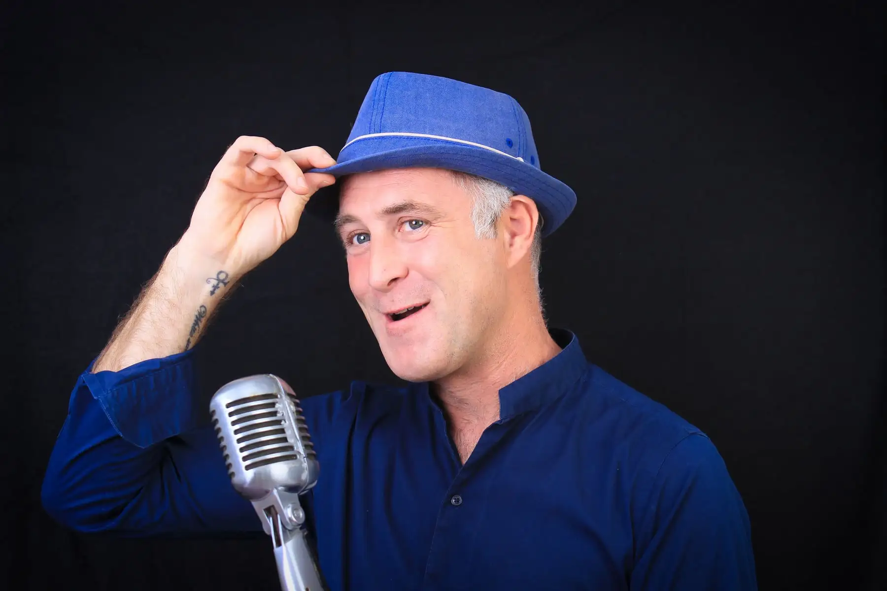 Studio portrait of Ian Preston with a vintage microphone